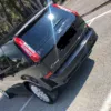 Black Ford C-Max parked outdoors, showing rear design with trees in the background.