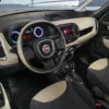 Interior view of a Fiat car showcasing the dashboard, steering wheel, and gear shift, highlighting modern design and features.