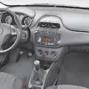 Interior view of a Fiat 500 dashboard with controls and gear shift, showcasing modern design and functionality.